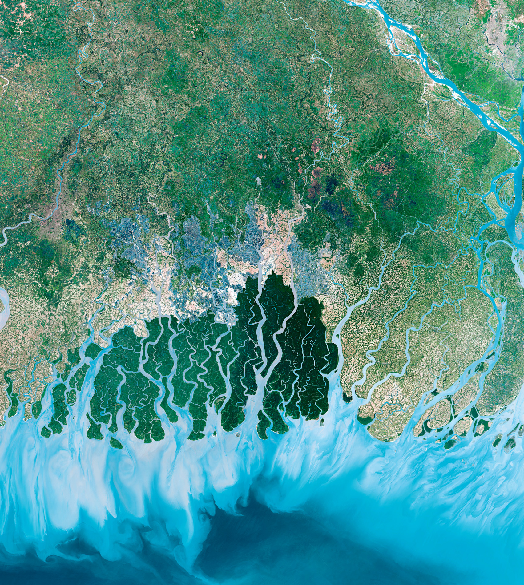 The Deimos-2 satellite captures an image of the Sundarbans, the world’s largest delta. The Ganges, Brahmaputra and several other rivers flow through India and Bangladesh, converging in the Bay of Bengal. Mangrove roots trap silt in the water, creating the largest mangrove forest on Earth. The dark green is the area protected as a national park, while farms and shrimp farms are on its borders. © 2018, Deimos Imaging SLU, an UrtheCast Company.