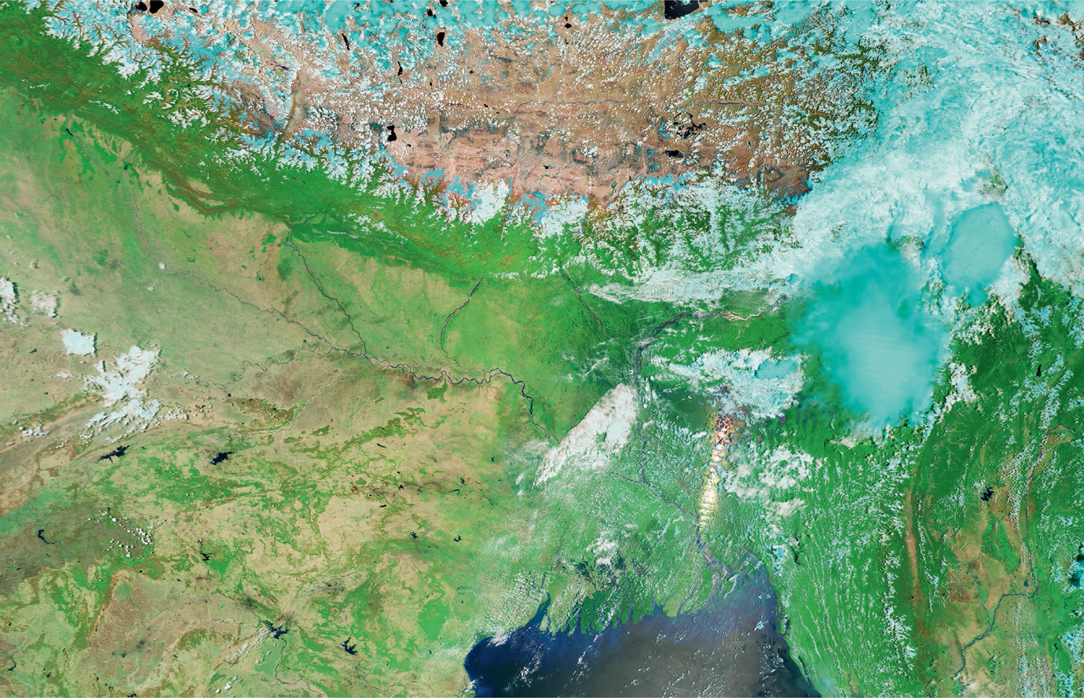 Plant growth on the Indian sub-continent is dependent on the rain delivered by the monsoon. The two satellite photographs show how the land changes colour from shades of brown before the monsoon (above) to green afterwards (here). The clouds in this image show up as blue. © NASA