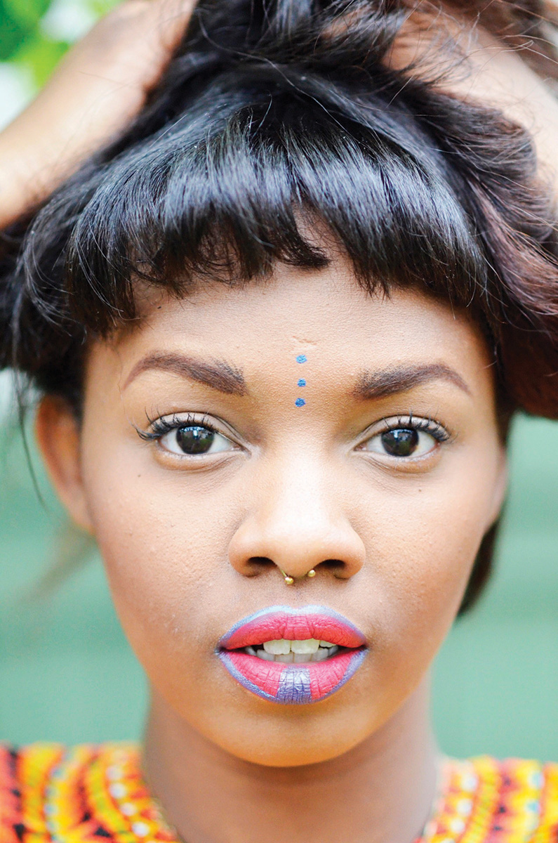 Close up photo of Zahra Siddiqui, a young black woman, wearing pink lipstick with a streak of purple down the centre of her mouth.