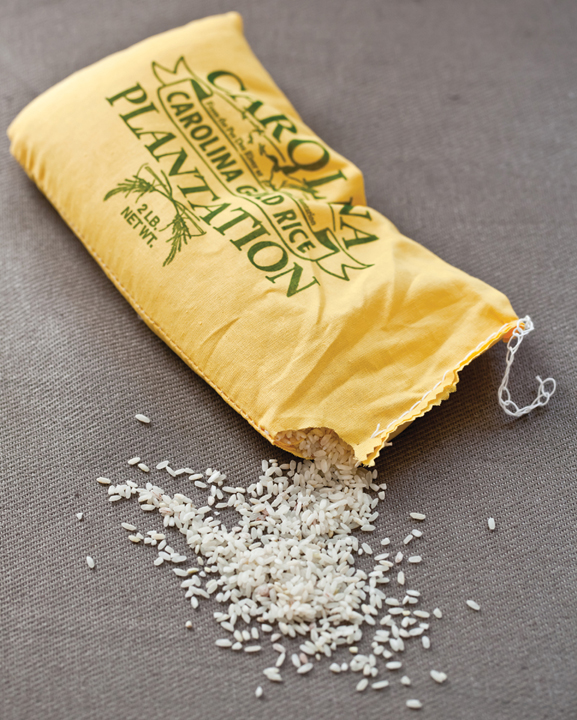 A yellow bag of Carolina rice cut at the corner, spilling grains