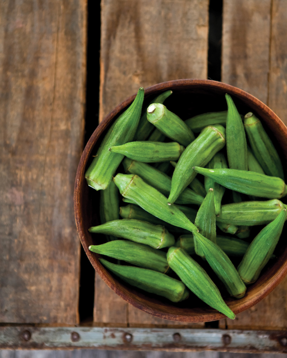 A wooden bowl filled with fresh okra