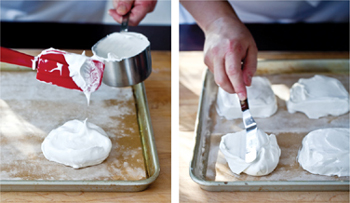 Scooping meringue out of a measuring cup onto a baking sheet and smoothing the tops of the heaps