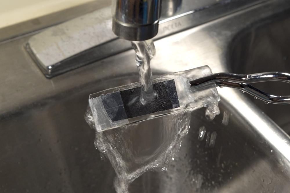 Rinsing a specimen after treating it with gentian violet solution