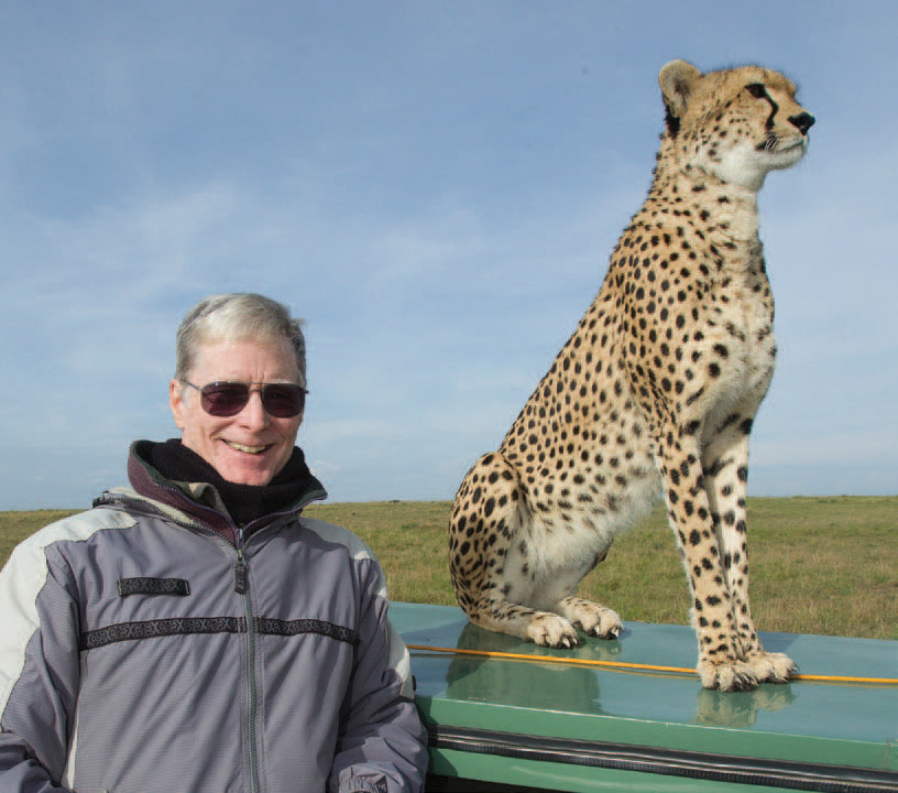 Joe McDonald with a wild Cheetah that frequently scouted for game from the rooftops of safari vehicles in Kenya’s Masai Mara Game Reserve. Photo by Mary Ann McDonald