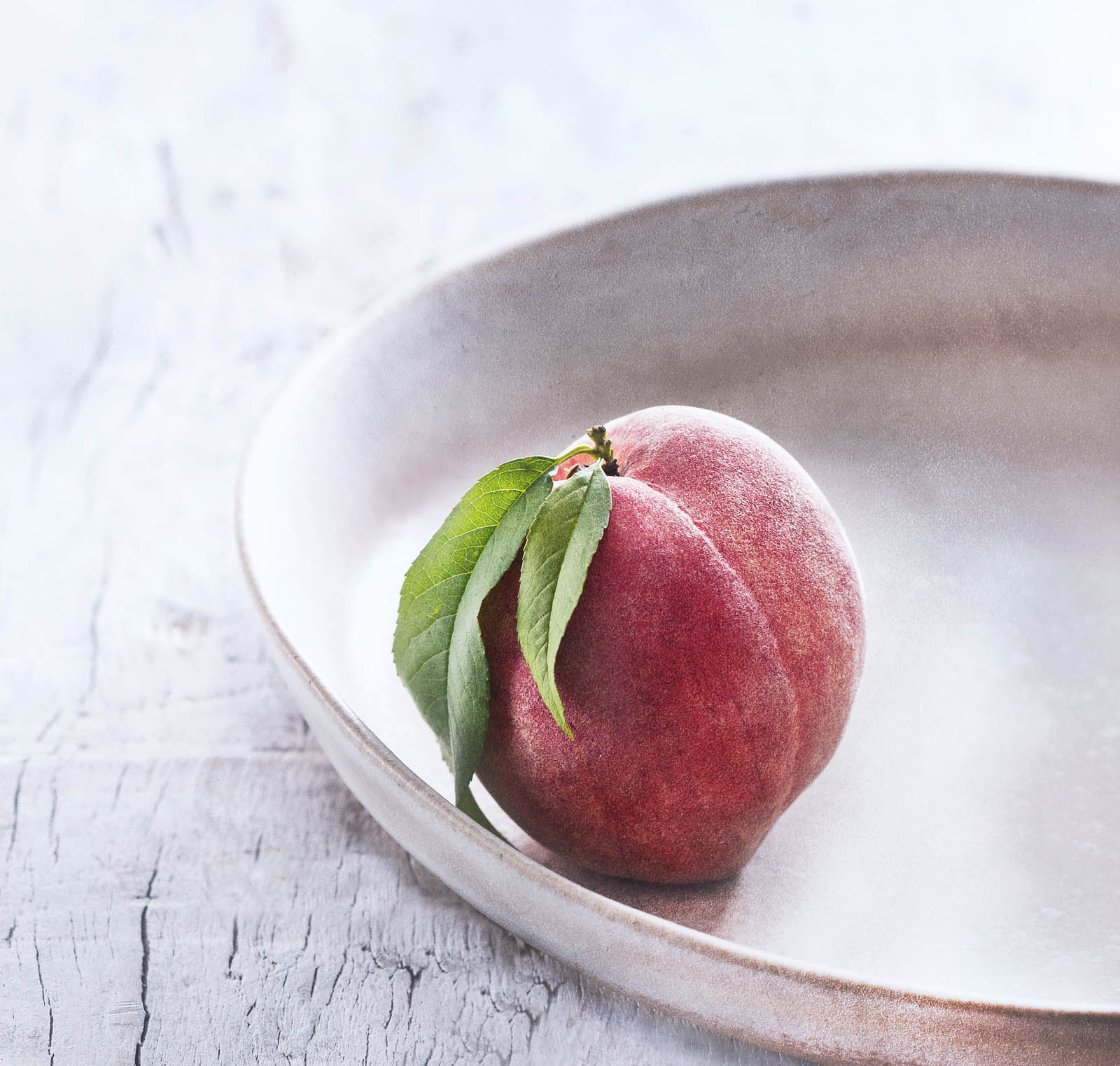 Photo of a peach in a bowl.