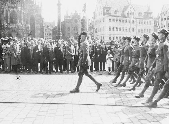 Adolf Hitler (3. v. l.) und rechts hinter ihm vermutlich Ernst Rˆhm verfolgen vor der Frauenkirche in N¸rnberg den Vorbeimarsch eines SA-Verbandes.