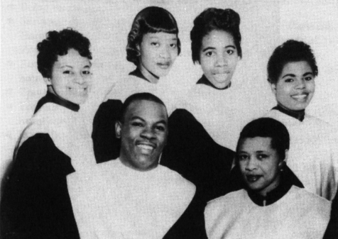 A photo of Reverend Lawrence Roberts posing with five female members of a choir.