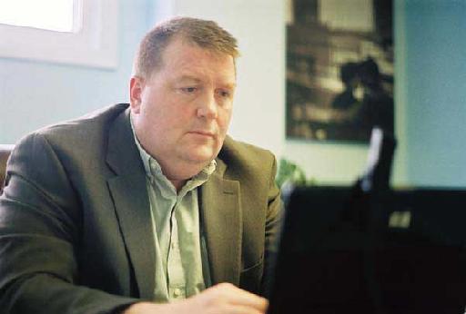 Mike Lewis seated at a desk.