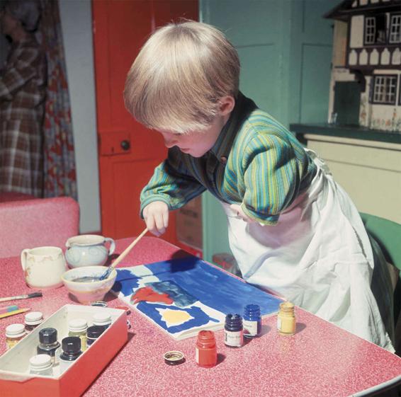 Photo of a child whose arms did not develop properly because of the mother’s use of thalidamide when pregnant. The child is creating a painting despite the shortened or absent limbs.