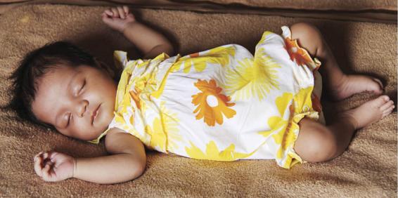 Photo of a baby sleeping on her back.