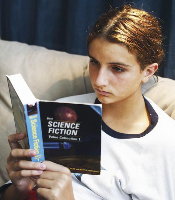 Photo of an adolescent reading a collection of science fiction stories.