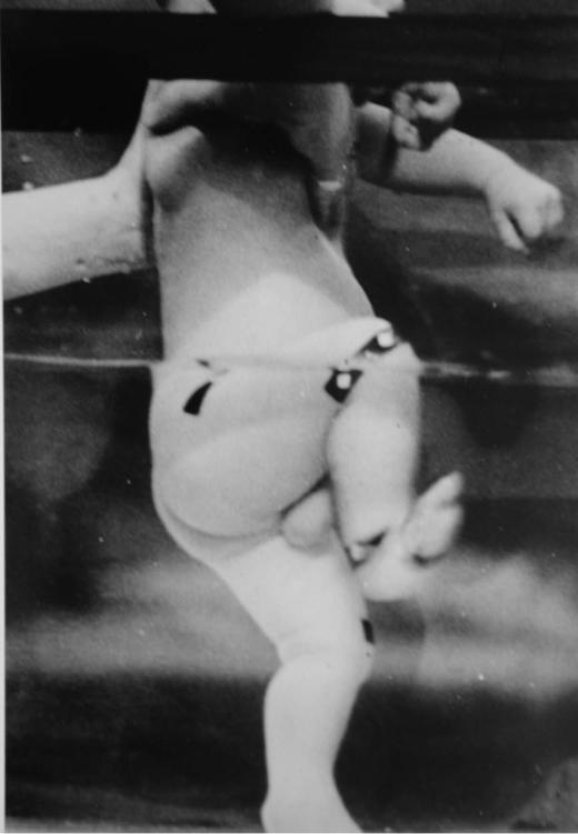 Photo of an infant displaying the stepping reflex in water, raising his foot to find the next solid place to put it.