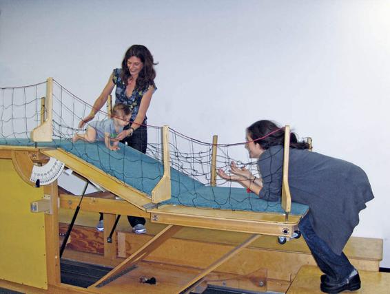 In the photo on the left, researchers are helping an infant crawl, keeping her from falling down a slope too steep for her crawling skills. In the photo on the right, a toddler is deciding that the slope is too steep for her to attempt.