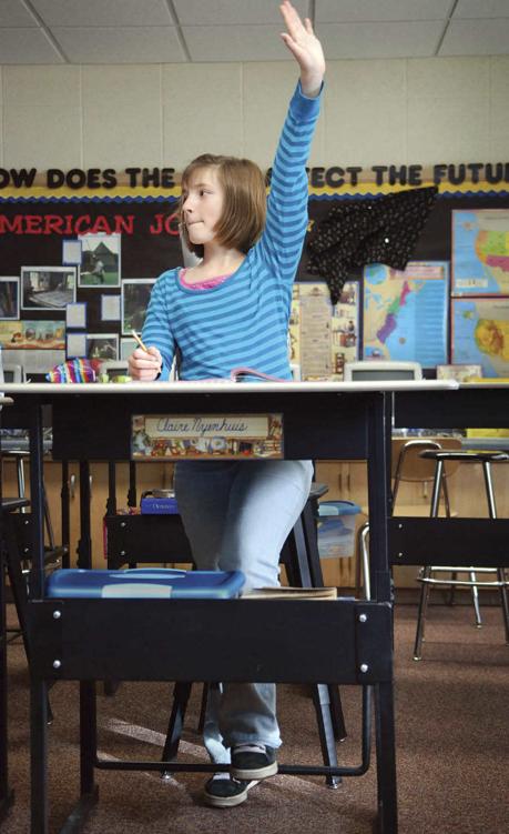 Photo of a student using a standing desk, being more active yet well-behaved during quiet classroom times.