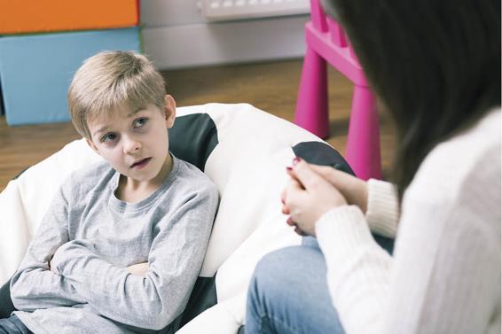 Photo of a boy talking to a therapist.