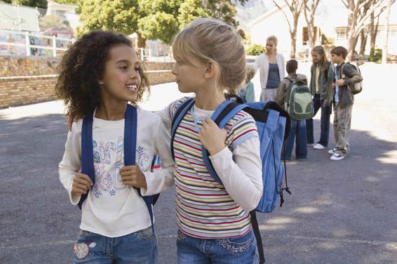 Photo of two girls talking by themselves, separate from the crowd.