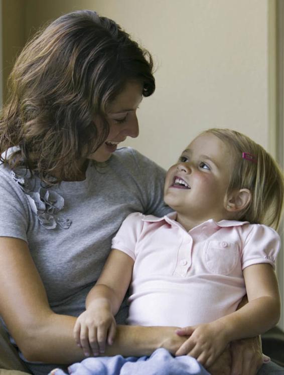 Photo of a mother talking to her young daughter, who is engaging verbally in response.