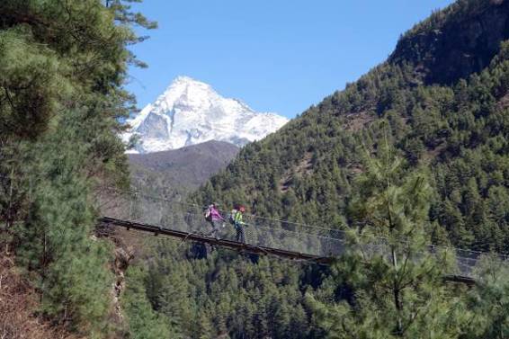 Edita and Margaret cross the Dudh Khosi on a suspension bridge, with Khumbila as a backdrop