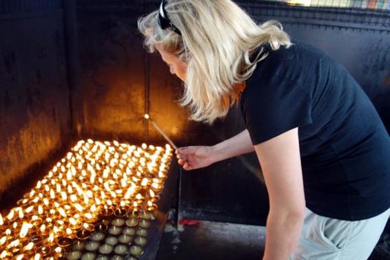 Edita lights a butter lamp for her friend Dorje Khatri and the other victims of the 2014 Everest avalanche