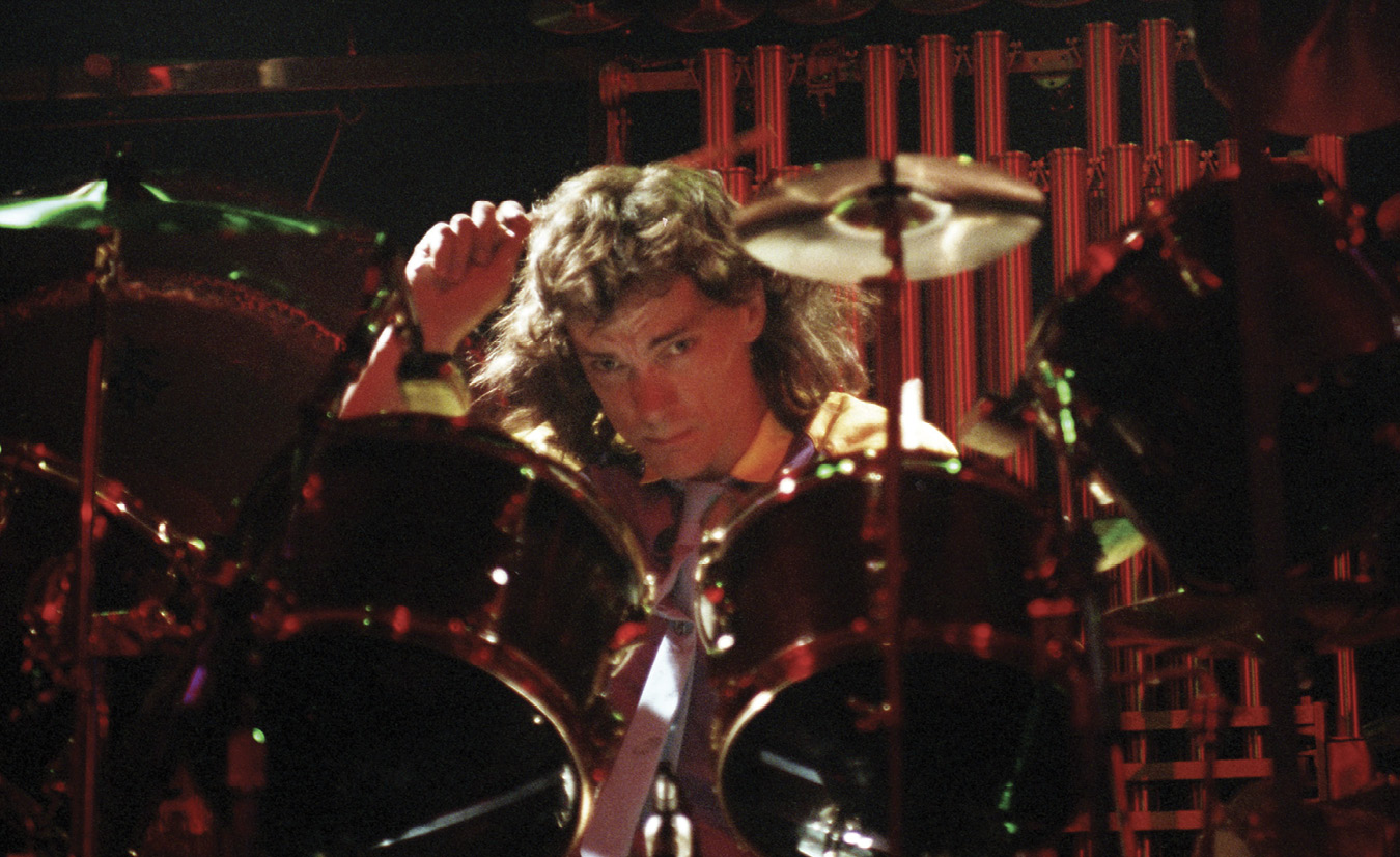 Neil, with long hair, plays the drums.