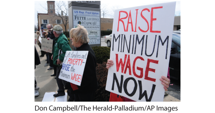 A photo shows a group of elders protesting on a sidewalk, with placards reading, ‘raise minimum wage now.’ 