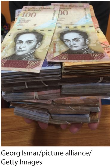 A photo shows a person holding stacks of Venezuelan bolivars.