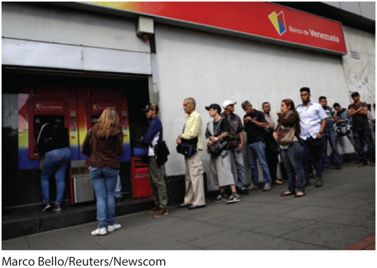 A photo shows a long line of people waiting in front of the Banco de Venezuela.