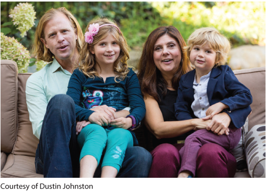 A family photo of a father, mother, and two children.