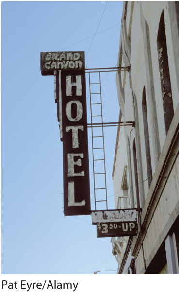 A photo of an old building with a board in the front that reads Grand Canyon Hotel.