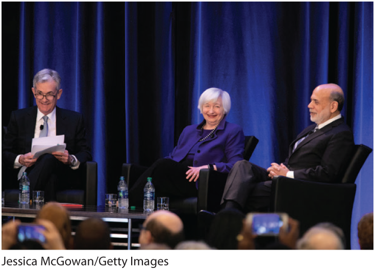 A photo shows Alan Greenspan, Janet Yellen, and Jerome Powell seated before an audience.