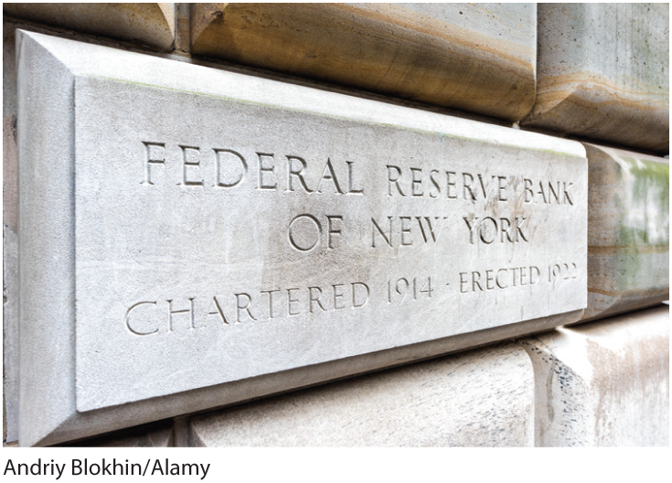 A photo shows a brick on the wall of Federal Reserve Bank with inscription that reads, Federal Reserve Bank of New York, Chartered 1914, Erected 1922.