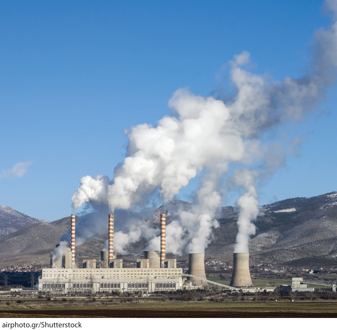 A photo shows thick smoke billowing out from the chimneys of a factory.