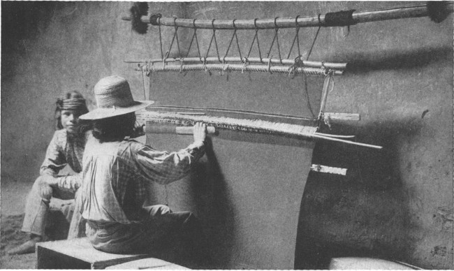 Copyright by H. S. Poley A Hopi Indian weaving a rug on a hand loom in a deserted cave