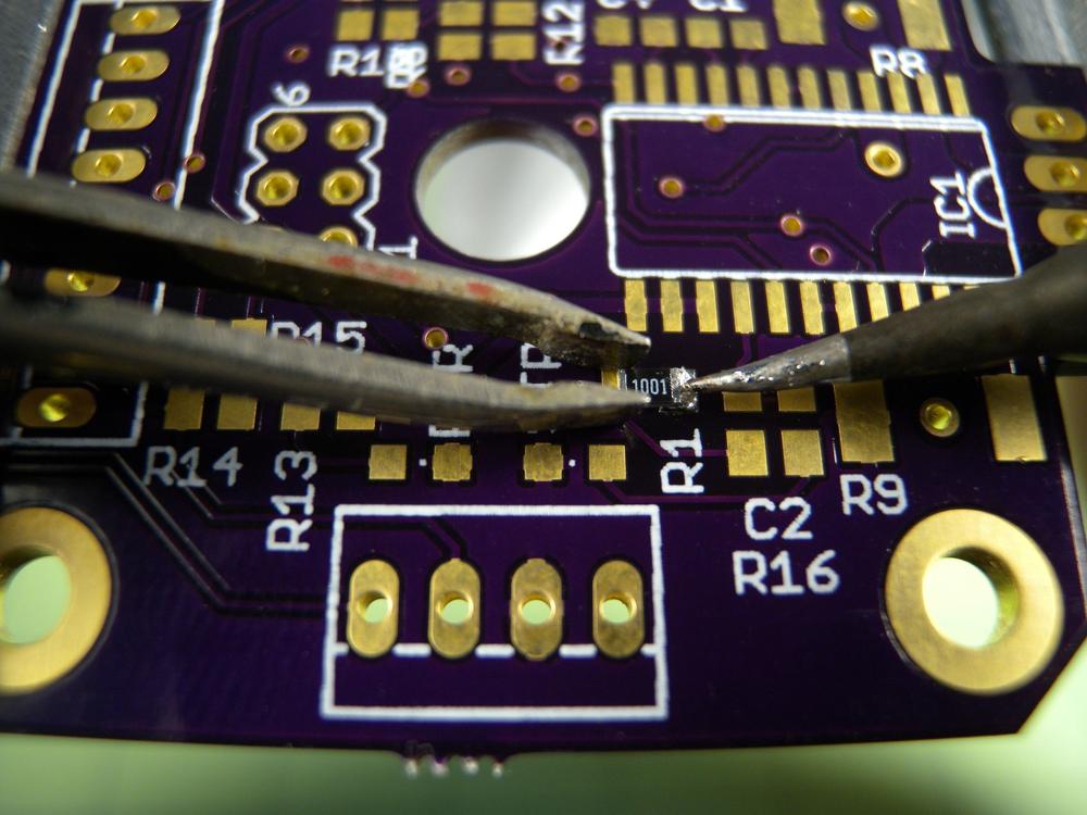 Hold the component in place with tweezers while soldering the pad. If the component shifts during the process, let it cool before reworking.