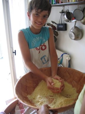 Saji transferring couscous grain for  steaming.