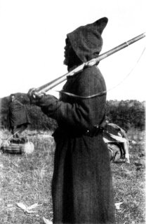 [Photograph: The Askari Patrols the Camp]