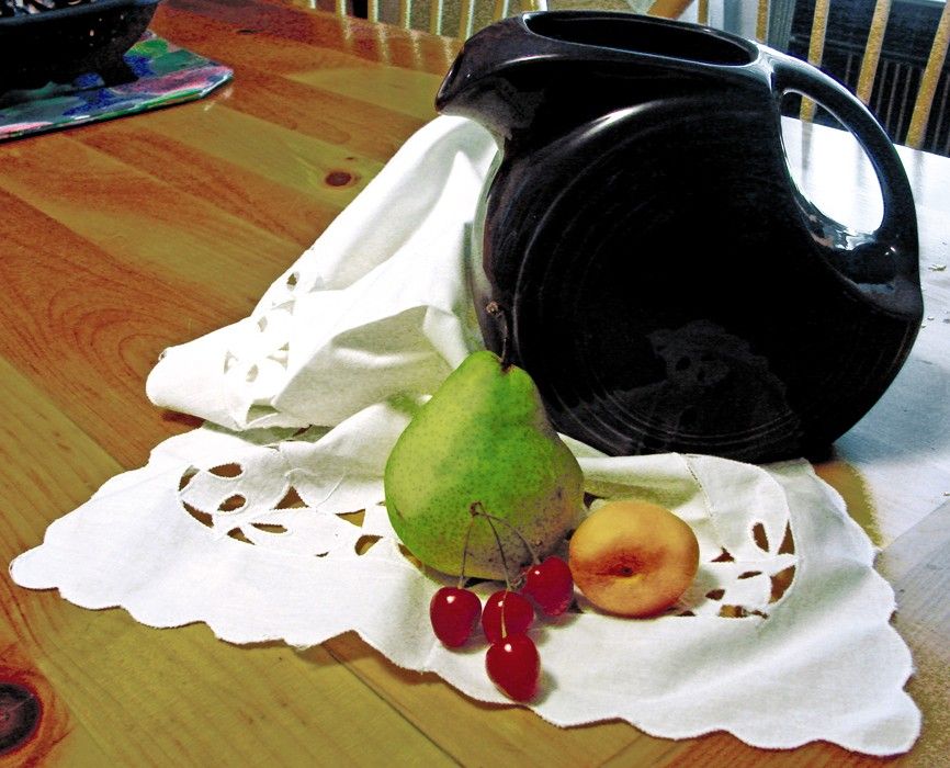 Figure 9-23: Still-life reference photograph with pitcher, cutwork, and fruit.