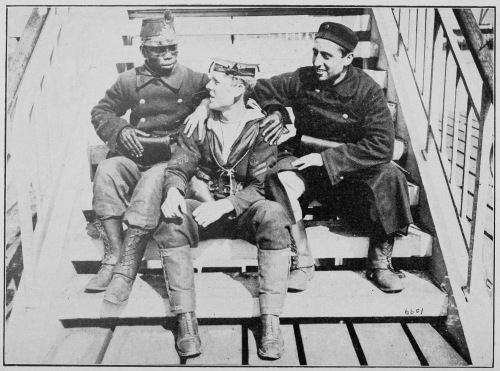 “ALLIES.” TWO BELGIAN SOLDIERS, ONE BEING FROM THE CONGO, HAVING A CHAT WITH A JACK TAR ON THE QUAY AT OSTEND. Photo by International News Service. 