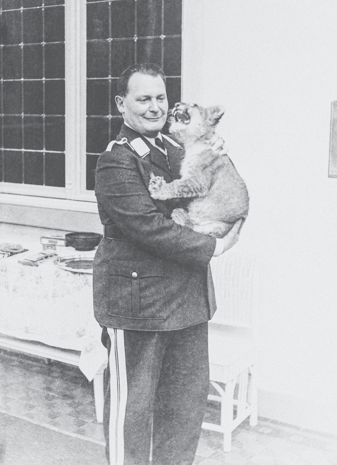 Hermann Göring holds a growling lion cub in his arms at his country estate.