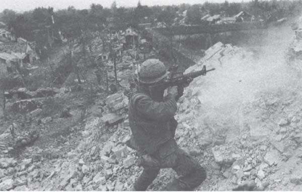 I believe that this is a Delta Company Marine, near the crest of the Dong Ba Tower, the scene of some of the bloodiest fighting inside the Citadel. The extended wall of the Citadel can be seen clearly in the upper right-hand section of the photo, and it is obviously much lower than the rubble on the tower. (UPI/Corbis-Bettmann photo)